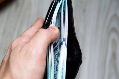 Elinde siyah deri bir cüzdanda 100 dolarlık banknot vardı. Yandan bak. Kapat.