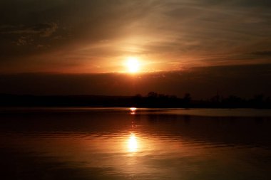 Karanlık bir anahtarla nehrin üzerinde gün batımı