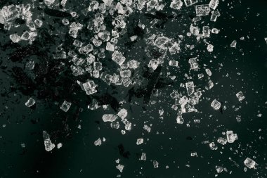 Karanlık bir arkaplanda makro görüntüde siyah bir sıçrama olan işlenmemiş kristaller