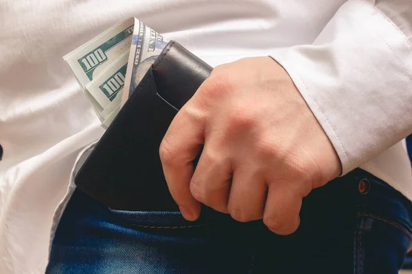 Man Lägger Handväska Sin Framficka Jeans Bunt Hundra Dollarsedlar Vit — Stockfoto