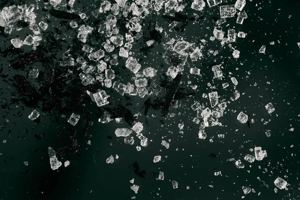 Karanlık bir arkaplanda makro görüntüde siyah bir sıçrama olan işlenmemiş kristaller