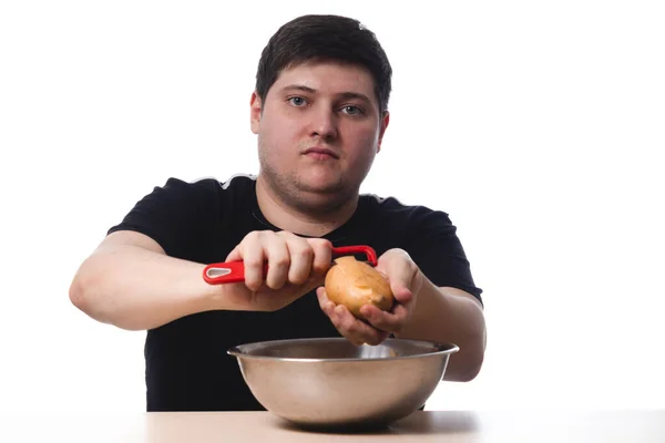 Young Guy Black Shirt Peels Potatoes White Background Isolate Copy — Stock Photo, Image