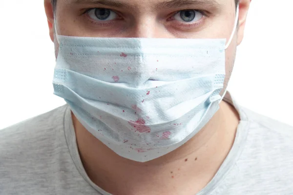 Beyaz arka planda kan tüberkülozu olan tıbbi maskeli bir adam. Kopyalama alanını kapat