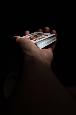 Siyah arka plan fotokopi alanı üzerinde poker kapağı olan bir deste kart kralı eldiveni. Kapat.