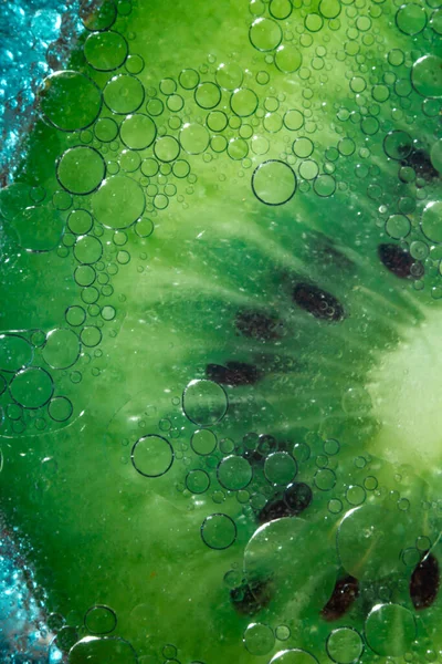 Grön Kiwi Med Gropar Med Bubblor Glas Blå Bakgrund Närbild — Stockfoto