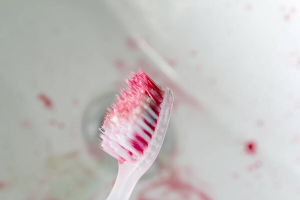 toothbrush with blood in the sink and toothpaste bleed gum copy space. close aps