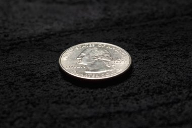 Siyah beton arka planda çeyrek dolar. Kopya alanı