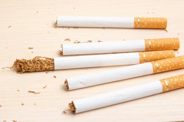 Beş sigara ve bir sigara hafif bir tahtanın üzerinde tütünün yarısıyla dışarı çıktı.