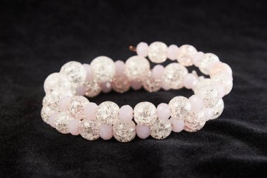 Pembe Mallorca incilerinden siyah kadife üzerine yarı değerli taşlar. Kapat.