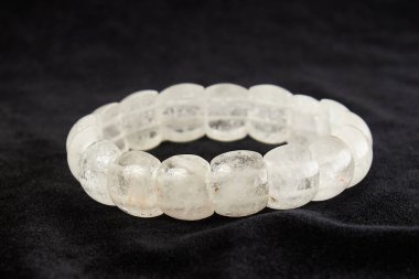 Kaya kristali bileziği siyah kadife üzerinde değerli taş. Kapat.