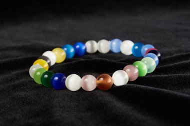 Kedi gözünden yapılmış bilezik siyah kadife üzerinde yarı değerli taş. Kapat.