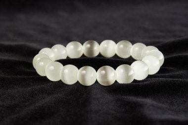 Kedi gözünden yapılmış bilezik siyah kadife üzerinde yarı değerli taş. Kapat.