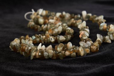 Kırıntı bir Labrador 'dan boncuklar siyah kadife üzerine yarı değerli bir taş. Kapat.