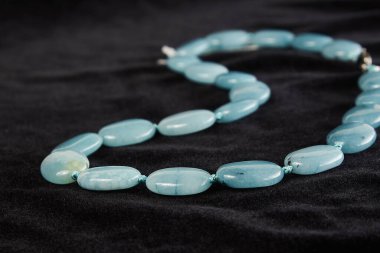 Siyah kadife üzerinde yarı değerli taştan boncuklar. Kapat.