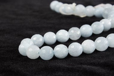 Siyah kadife üzerinde yarı değerli taştan boncuklar. Kapat.