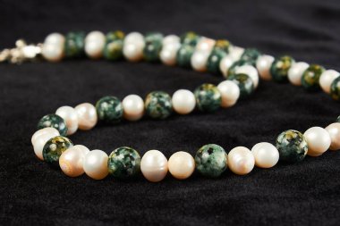 Siyah kadife üzerinde yarı değerli taştan boncuklar. Kapat.