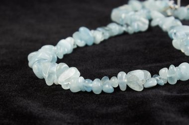 Siyah kadife üzerinde yarı değerli taştan boncuklar. Kapat.