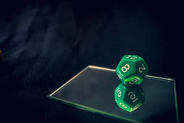 12 sided green die for a game on a mirror — Stock Photo, Image