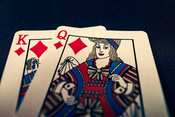 King and queen of diamonds playing cards on black background