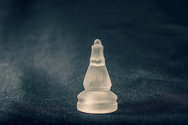 Padělané bílé sklo rytíř šachy kus na dramatickém pozadí — Stock fotografie