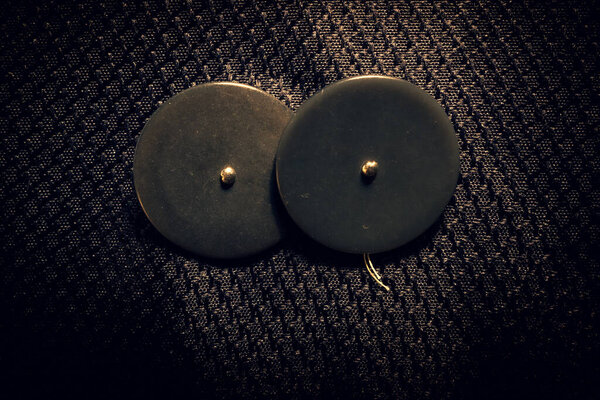 abstract sewing buttons and beads on black background