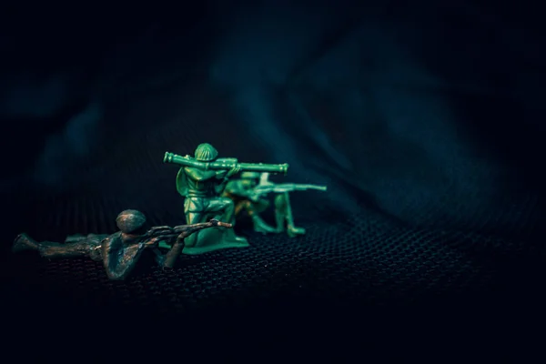Green plastic toy army men in firing line