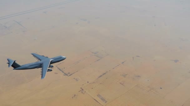 空軍軍事貨物輸送飛行機が昼間で中東やアフリカの砂漠の土地の上を飛んでします でレンダリングされる現実的な アニメーション — ストック動画