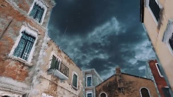 洪水の間の豪雨で嵐の空の背景に対する古代の歴史的建造物を見上げますイタリアのヴェネツィアのアクア アルタ 4Kでレンダリングされた悪天候の概念現実的な3Dアニメーション — ストック動画