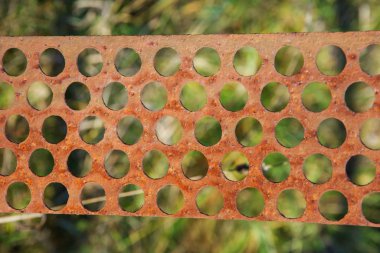 Yuvarlak delikleri olan paslı metal plaka. Soyut arkaplan.
