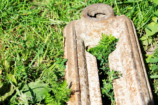 Velho pedaço enferrujado de ferro no fundo da grama verde — Fotografia de Stock