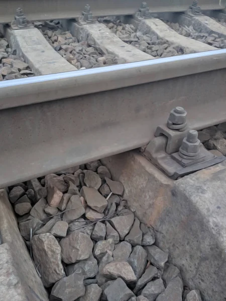 Vista em parafusos de fixação de trilhos ferroviários para laços cruzados de concreto. Parafusos enferrujados e velhos e porcas para fixação de trilho e dormentes. Os caminhos-de-ferro existentes. Foco suave seletivo . — Fotografia de Stock