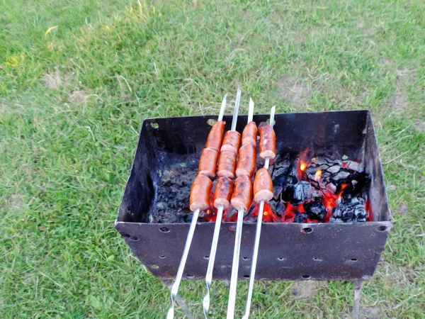 Šťavnaté smažené uzeniny smažené na grilu na uhlíky. — Stock fotografie