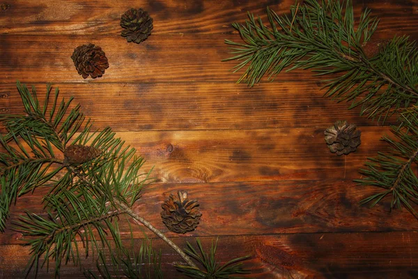 Christmas Fir tree green branches and pine cones on dark wooden rustic background. Xmas decoration frame. — Stock Photo, Image