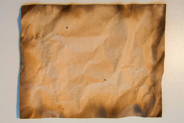 Burnt paper texture. Old crushed paper with the burned edges. Burned edges paper on white background for copy space.