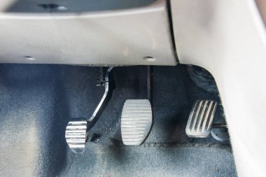 Manüel vitesli üç pedal. Debriyaj, fren, arabanın gaz pedalı.