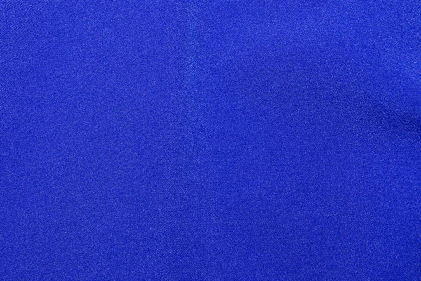 A textura de um tecido de lã de malha na cor clássica azul na moda. Fundo abstrato para design com ondas suaves — Fotografia de Stock