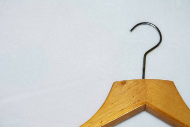 Boş ahşap elbiseler parlak beyaz arka planda asılı. Giyecek hiçbir şey yok.