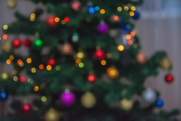 Suddig julgran gran med krans. Oskärpa abstrakt jul bakgrund, ljus oskärpa skapa fina bokeh, röd vit och orange. — Stockfoto