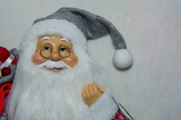 Jultomten håller en väska med presenter på en vit snö bakgrund. God Jul och Gott Nytt År symbol. Upphovsrätt. — Stockfoto