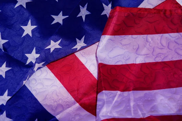 Pluie sur le drapeau américain. La pluie tombe sur le drapeau américain mouillé. Gros plan d'un drapeau américain avec fond de gouttes de pluie . — Photo