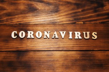 Koyu tahta masa arkasında Coronavirus kelimesi. Çin korona virüsü salgını.