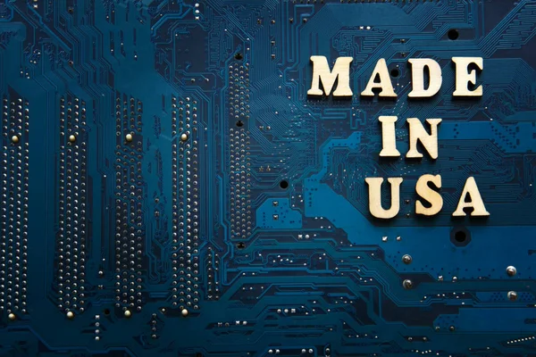 Made in Usa. Inscription on a blue electronic printed circuit board. American electronics industry concept. Background with copyspace for design.
