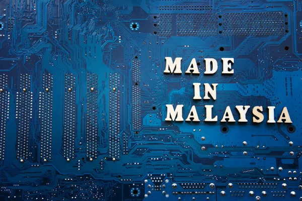 Inscription Made in Malaysia on a blue electronic printed circuit board. Background with copyspace for design. Malaysia electronics industry concept. — Stock Photo, Image