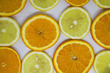 Beyaz üzerine portakal ve limon dilimleri, arka plan gibi görünüyor.