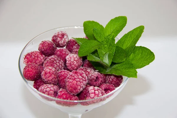 Bevroren Frambozen Met Muntblaadjes Een Witte Achtergrond — Stockfoto