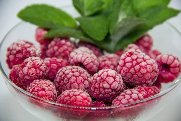 Bevroren Frambozen Met Muntblaadjes Een Witte Achtergrond — Stockfoto