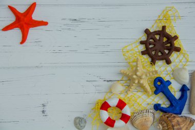 Deniz dekoru. denizyıldızı cankurtaranı direksiyon çapası beyaz ahşap arka planda deniz kabukları