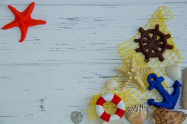 Deniz dekoru. denizyıldızı cankurtaranı direksiyon çapası beyaz ahşap arka planda deniz kabukları