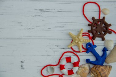 Deniz dekoru. denizyıldızı cankurtaranı direksiyon çapası beyaz ahşap arka planda deniz kabukları