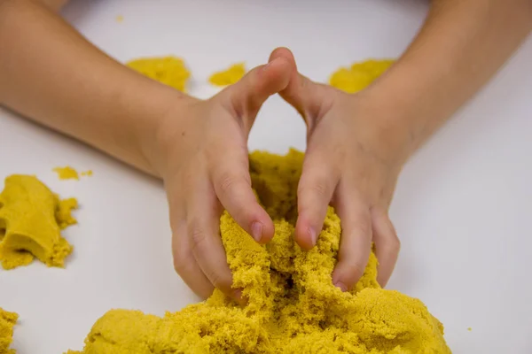 Les Mains Des Enfants Jouent Sable Cinétique Jaune Sur Une Image En Vente